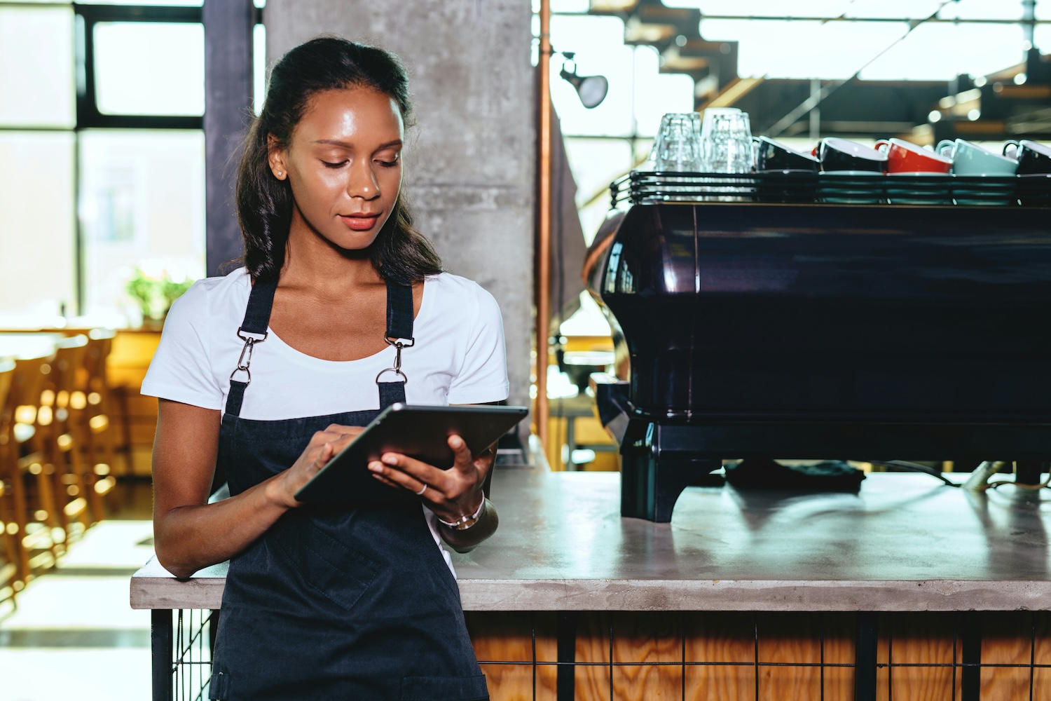 A team member checking Youda on a tablet behind the bar during a shift